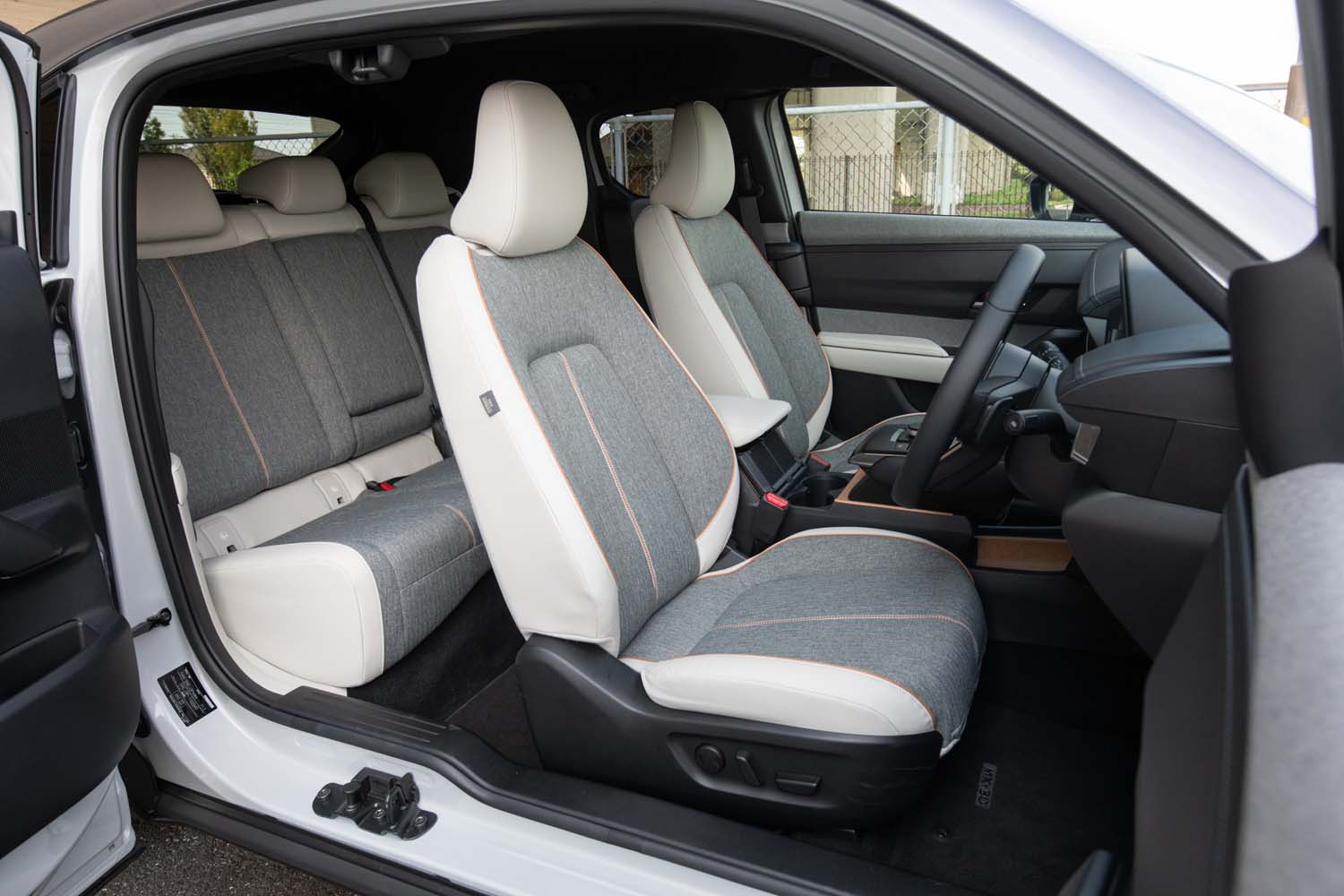 ホワイト内装車のシート表皮はホワイトの合皮とメランジ調のクロスの組み合わせ。オレンジステッチのアクセントがおしゃれだ。