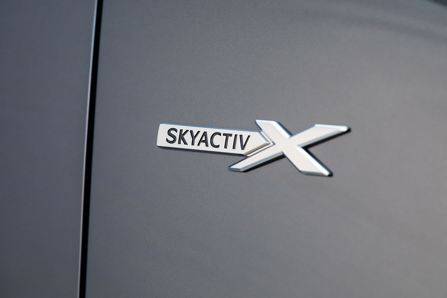 フロントフェンダーに装着される「SKYACTIV X」バッジ。従来装備されている大型マフラーカッターともども、他のエンジン搭載車との差別化が図られている。