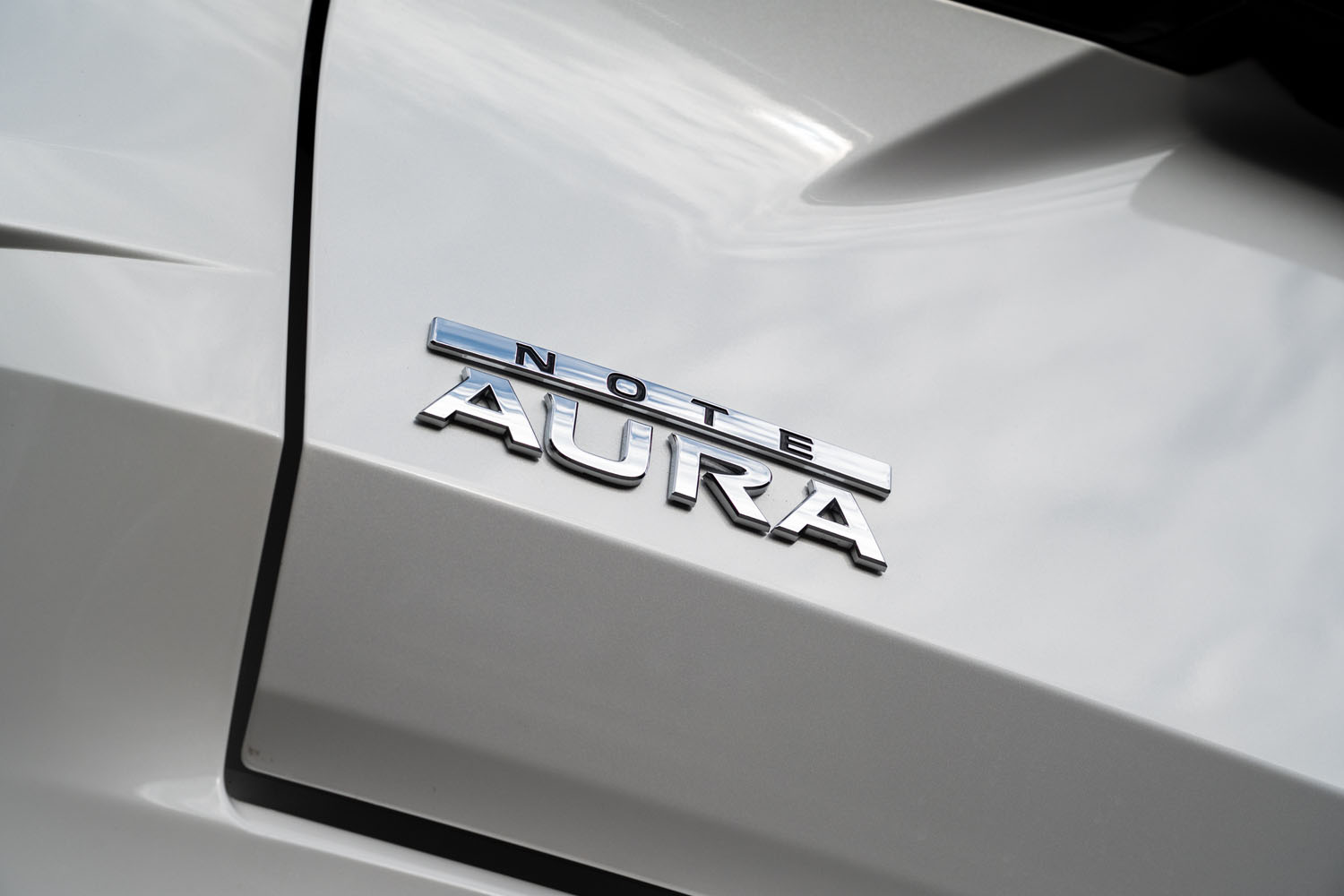 テールゲートに装着された「NOTE AURA」のバッジ。同車は「ノート オーラ」だったり「オーラ」だったり「オーラe-POWER」だったりと、カタログやウェブサイトなどで使われる車名の表記が定まっていない。