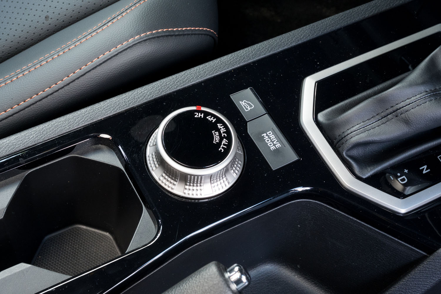 センターコンソールに備わる「ドライブモード」の切り替えボタンと、ダイヤル式のトランスファーのコントローラー。リアデフロックのボタンはダッシュボード側、空調パネルの下に備わる。