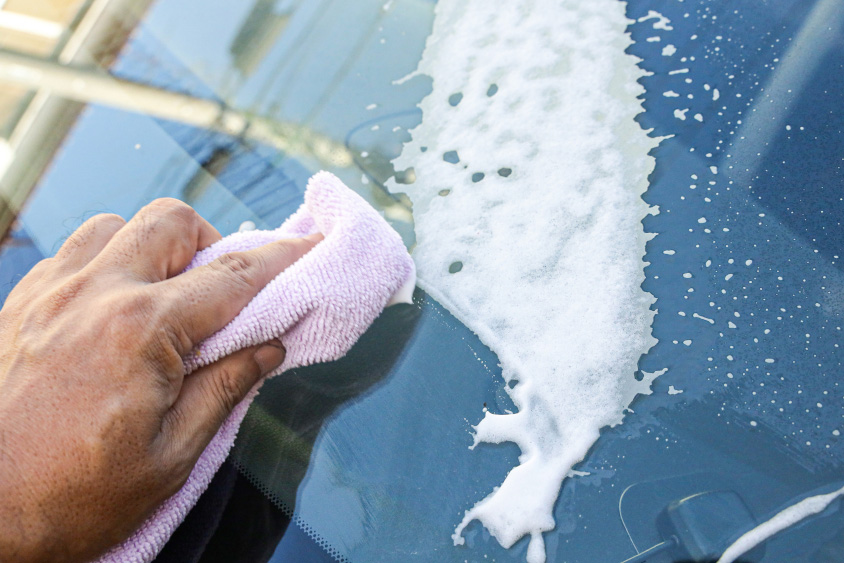 ガラスクリーナーでフロントガラスを拭く