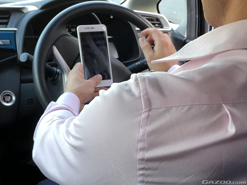 スマホを持ちながら運転する男性