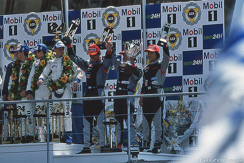 3位表彰台でトロフィーを掲げる星野一義、鈴木亜久里、影山正彦