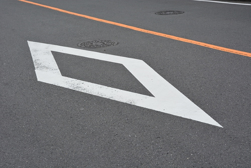 信号のない横断歩道の手前にある白いひし形の標示。この先に横断歩道があることを示す。（写真：鈴木ケンイチ）