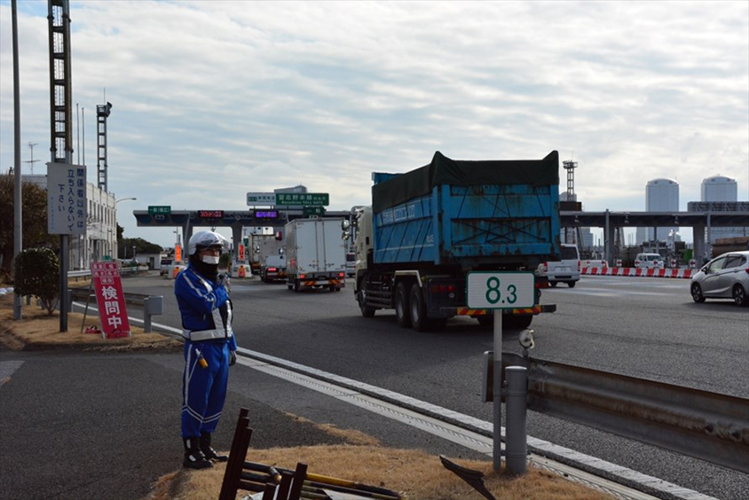「検問中」の看板を出して、違反車両がいないかを目視でチェックする車限隊の隊員