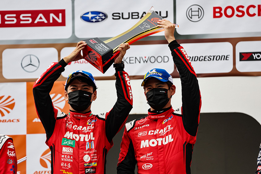 優勝トロフィーを掲げる千代 勝正選手と高星 明誠選手/NDDP RACING