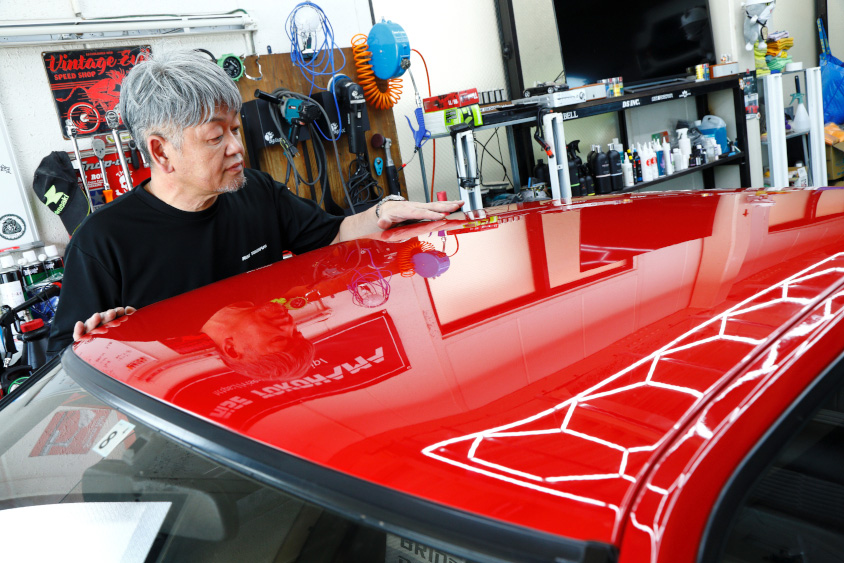 トヨタ・スプリンタートレノAE86「赤パン」の磨き具合をチェックするライズヨコハマの荻洲さん