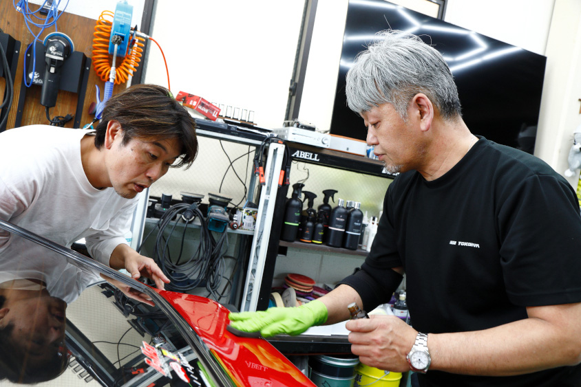 トヨタ・スプリンタートレノAE86「赤パン」の磨きについて教えるライズヨコハマの荻洲さん