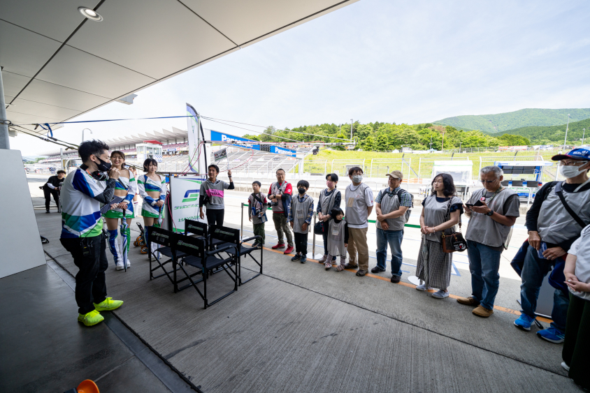 ピットツアーでSHADE RACINGの川谷高徳監督から説明を受ける参加者のみなさん