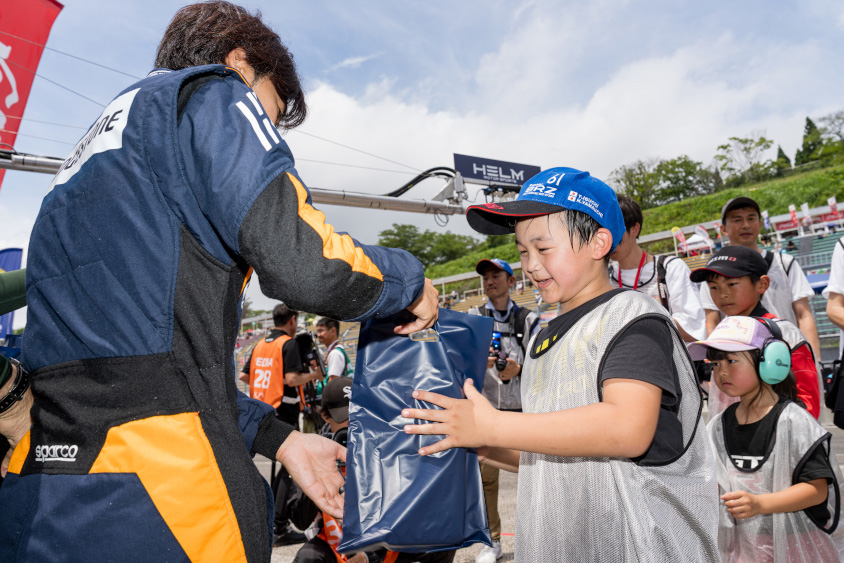 GAZOOピットツアーでお土産をもらうお子さん