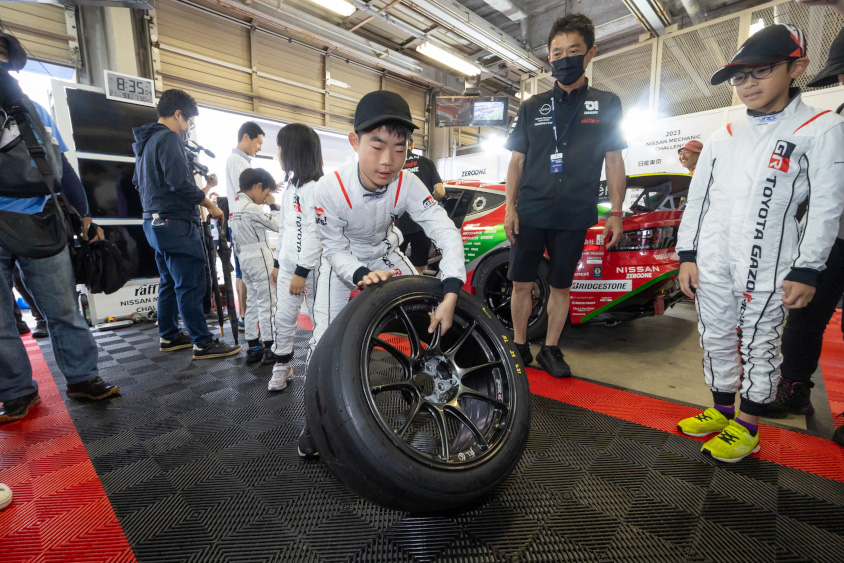 GAZOO.com愛車ピットツアーでタイヤを持ち上げるお子さん