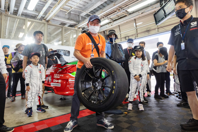 GAZOO.com愛車ピットツアーでタイヤを持ち上げる参加者