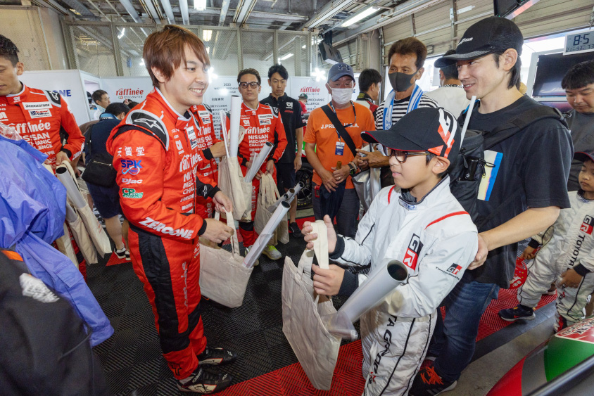 GAZOO.com愛車ピットツアーでお土産をもらう様子