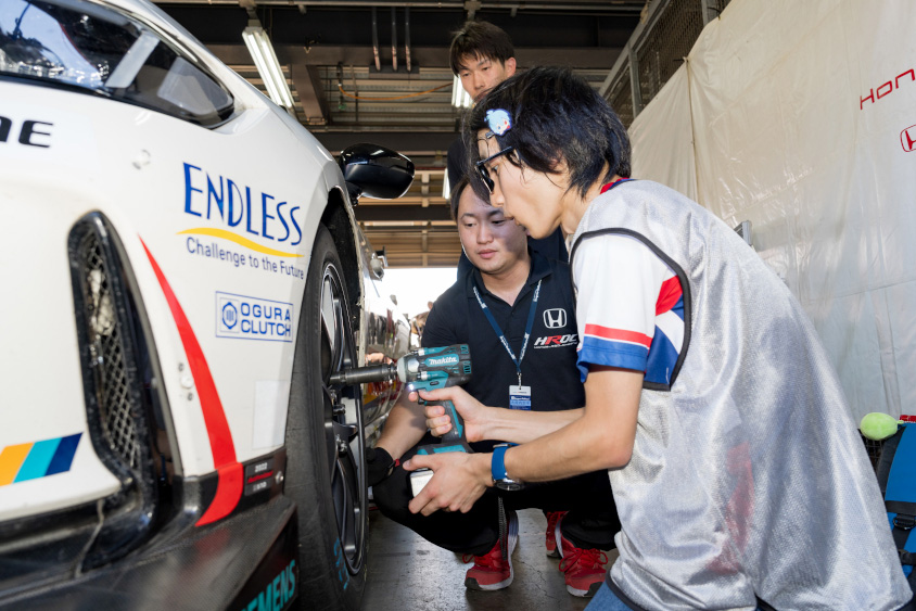 Honda R&D Challenge FL5のタイヤをインパクトで締める男性