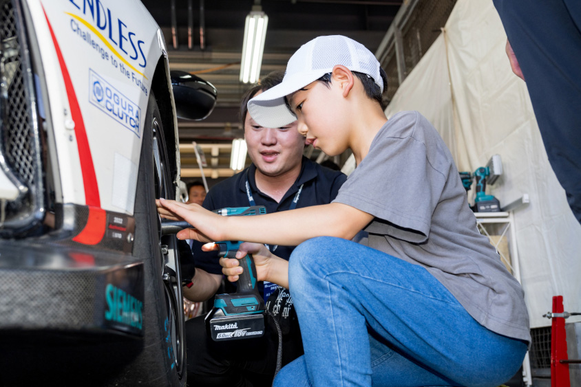 Honda R&D Challenge FL5のタイヤをインパクトで締める少年