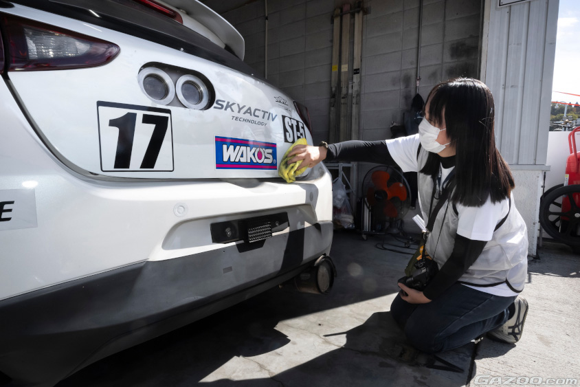 ピットツアーでマシンを拭く参加者