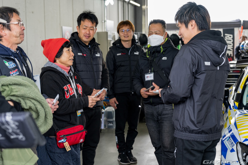 ORC ROOKIE Racingの共挑ピットツアーではドライバーからノベルティを手渡し