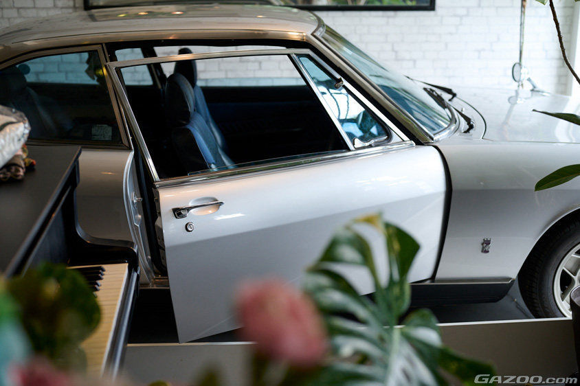 愛用のグランドピアノの隣と並ぶいすゞ・117クーペ