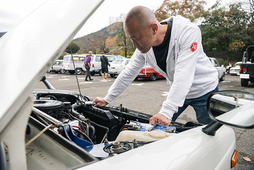 トヨタ・スターレットバン（KP61V）のエンジンルームを覗く間芝さん