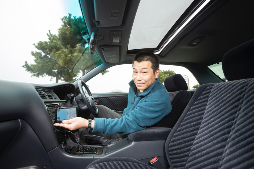 トヨタ・マークII(JZX100)の運転席に座る藤原さん