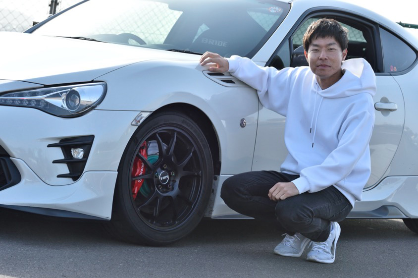 トヨタ・86の横に座るオーナーのやじさん