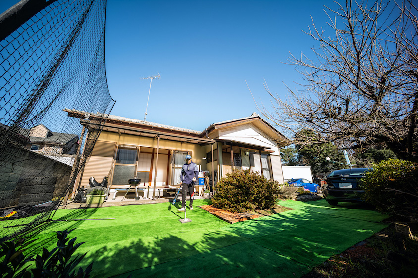 庭で野球のバットを握るマリオ高野さん