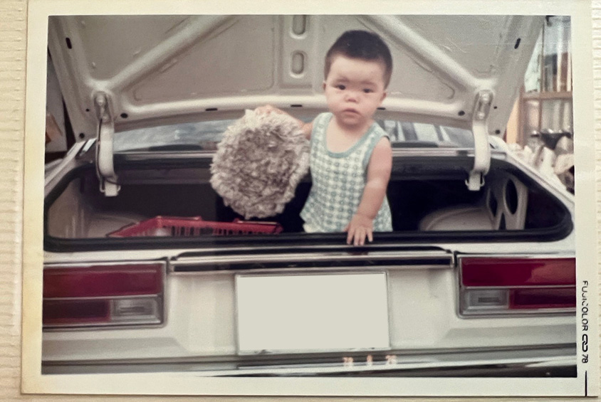 三菱・ギャランのラゲッジに乗る冨澤さん