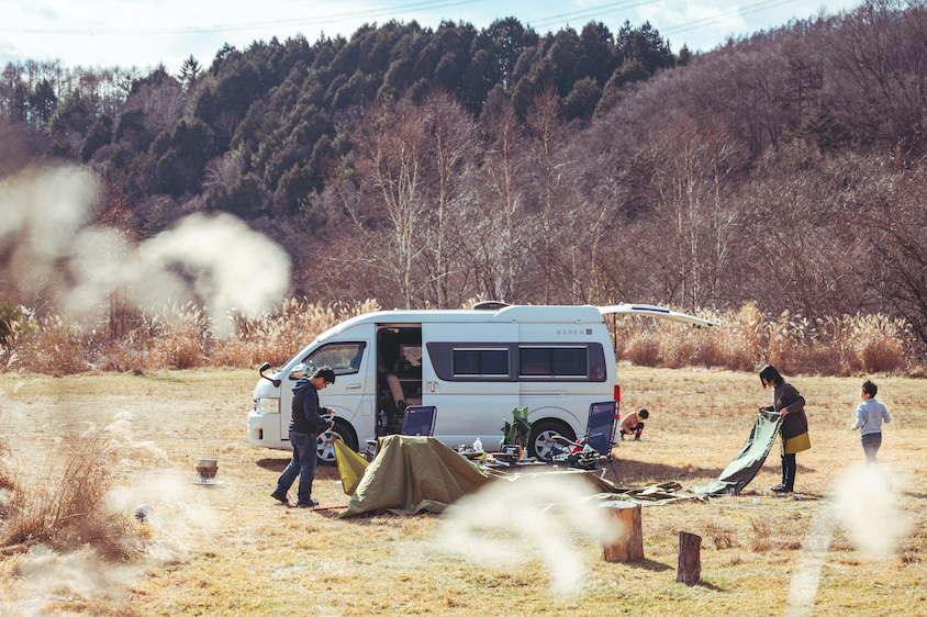 草原でキャンプの準備をするトヨタ・ハイエースとオーナーの𡈽田さん