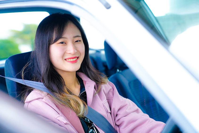 トヨタ・スターレットの運転席から笑顔を見せるはるかさん