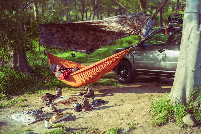 トヨタ・プロボックスの前でハンモックで休む石井良さん