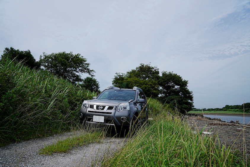 川沿いの砂利道を走る日産・エクストレイル
