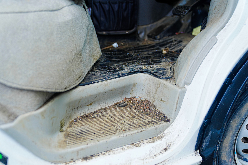 泥だらけのスズキ・エブリイの運転席