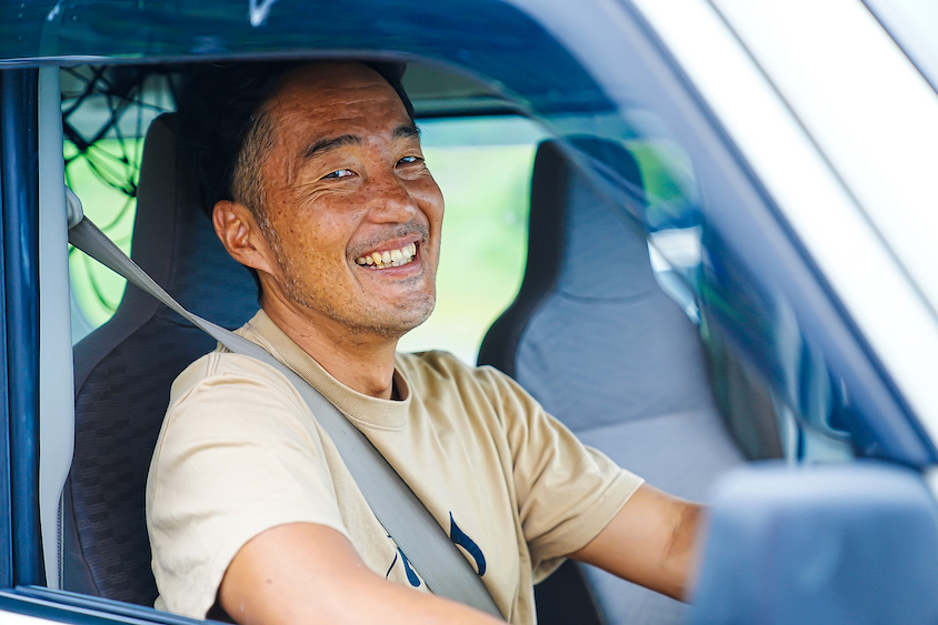 スズキ・エブリイの運転席に座る塚越さん