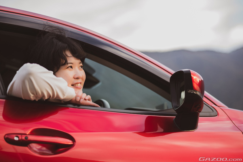 マツダ・MAZDA 2の運転席から夕陽を眺める森本さん