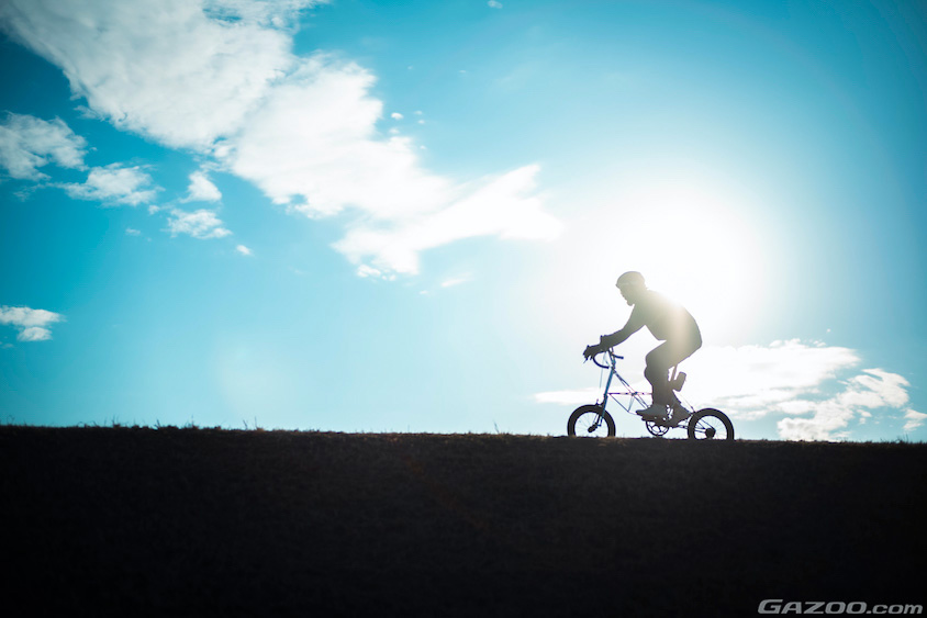 トヨタ・FJクルーザーと自転車で走る寺田さんのシルエット