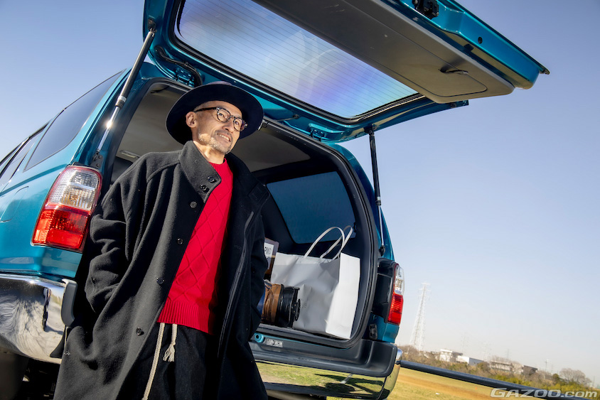 リアハッチの開いたトヨタ・ハイラックスサーフと岡田聖さん