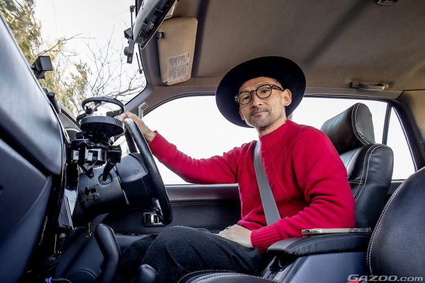 トヨタ・ハイラックスサーフの運転席に座る岡田聖さん