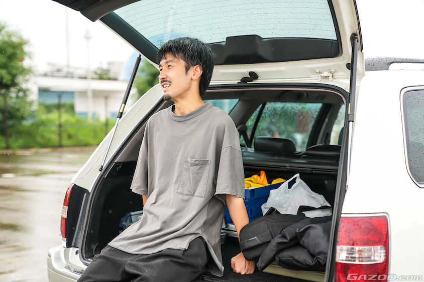 トヨタ・クラウンエステート（170系）のラゲッジルームに座る小塚さん