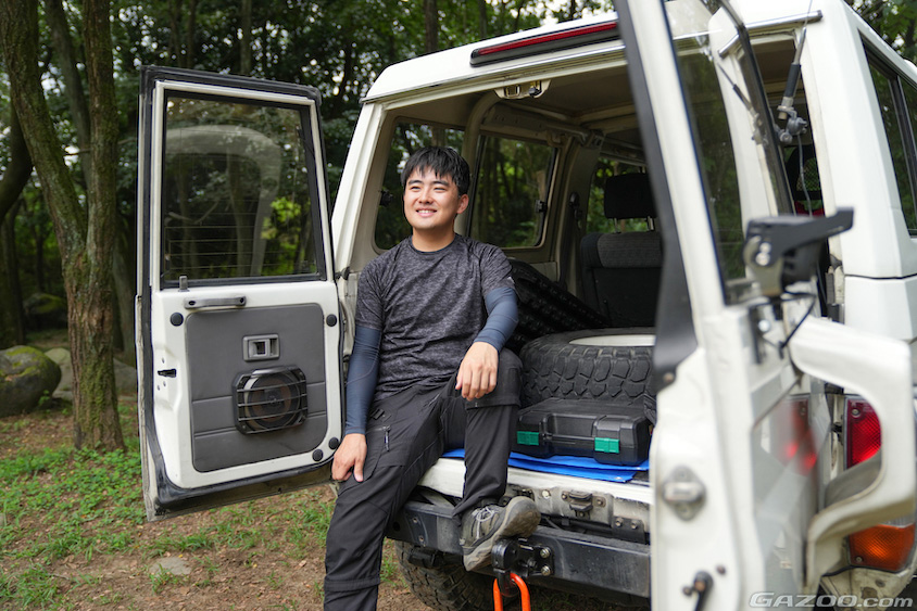 トヨタ・ランドクルーザー70のラゲッジに座るオーナー