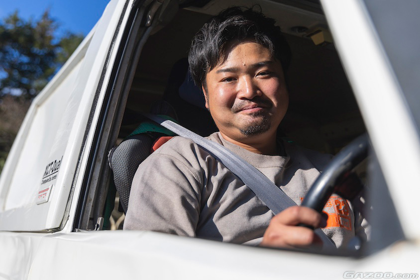トヨタ・ランドルーザー70の運転席から笑顔を見せるオーナーさん