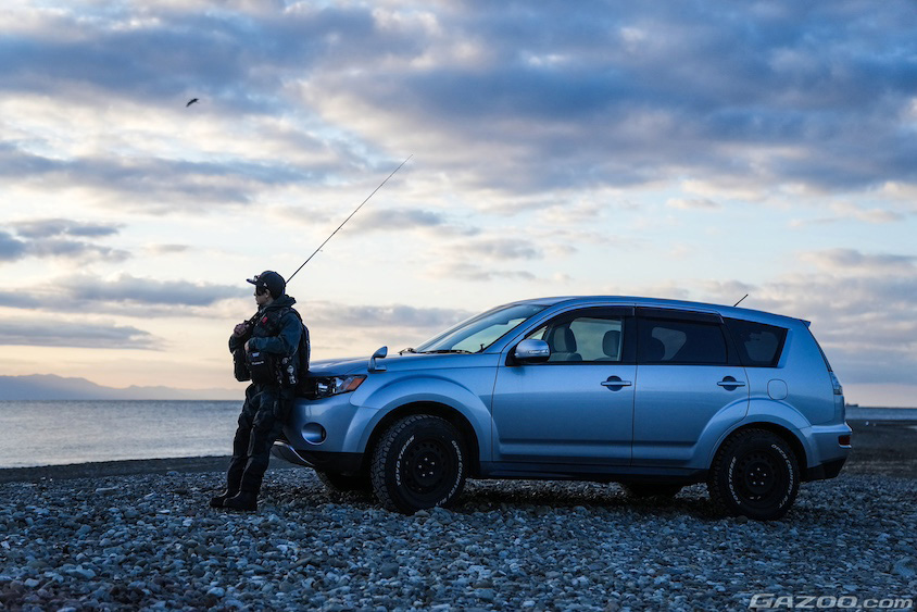夜明けの海岸にたたずむ三菱・アウトランダーとオーナーさん