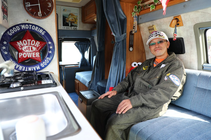 キャンピングカー仕様のフォード・エコノラインでくつろぐオーナーの福島さん
