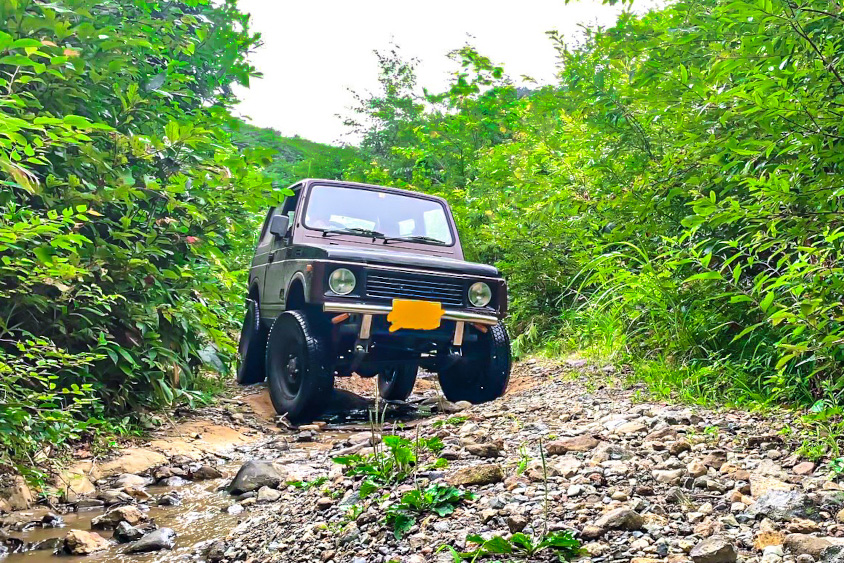 砂利道を走るスズキ・ジムニー(SJ30)