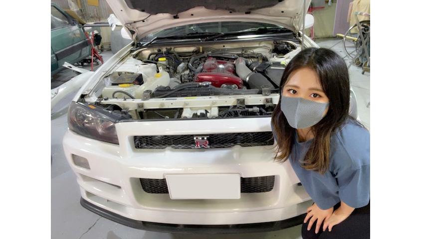 R34型スカイラインGT-Rの前でほほ笑むオーナーのなつこさん