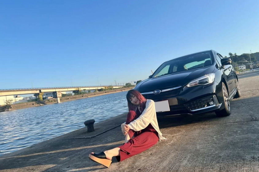 スバル・インプレッサG4の前に座るZukichanさん