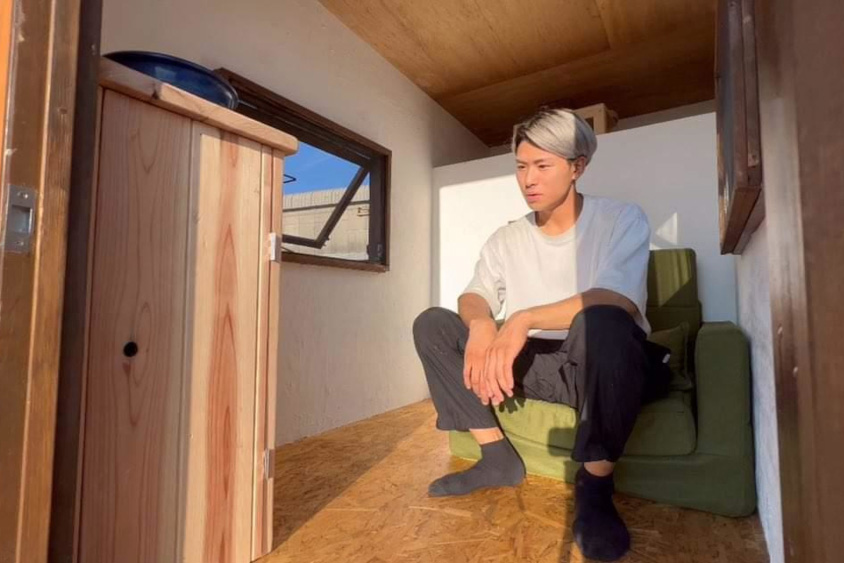 軽トラキャンパーの自作シェルの室内に座る森元さん