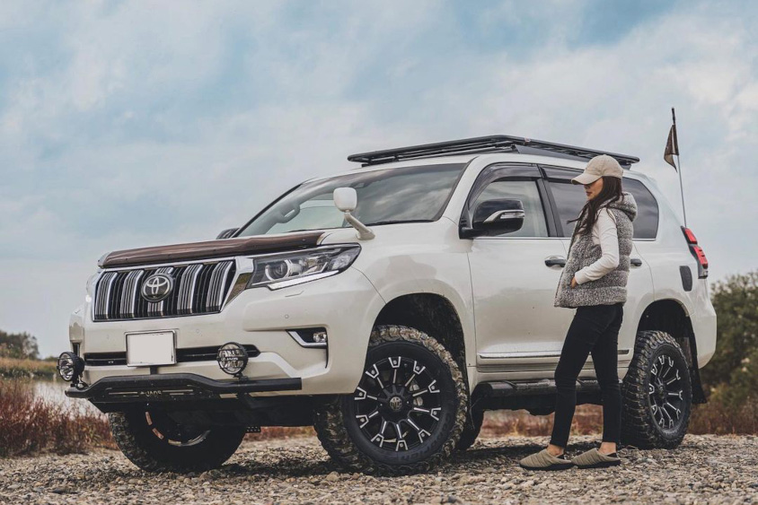 トヨタ・ランドクルーザープラドの前に立つAZUさん