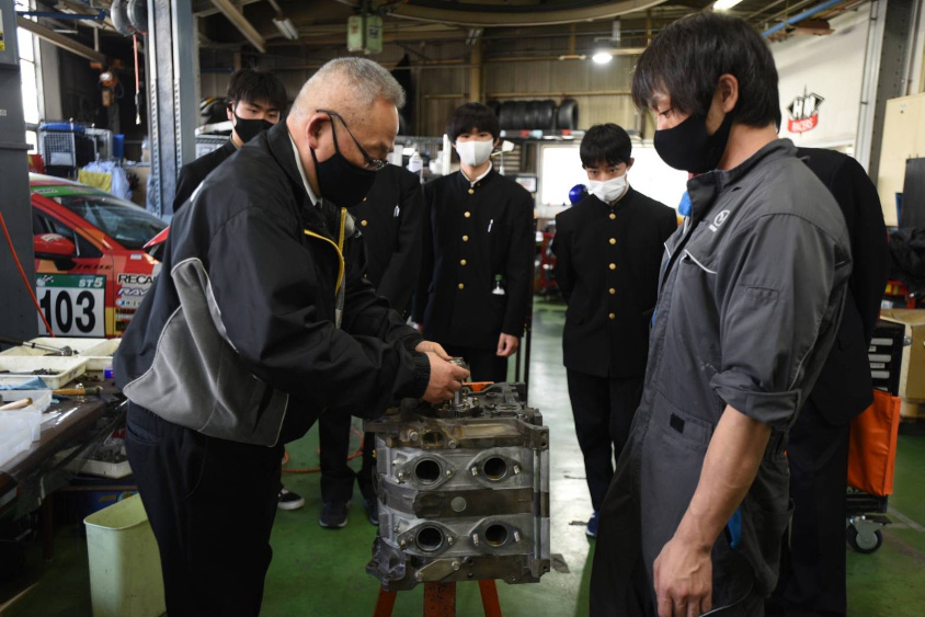 若手エンジニアにエンジンについて教える河尻さん
