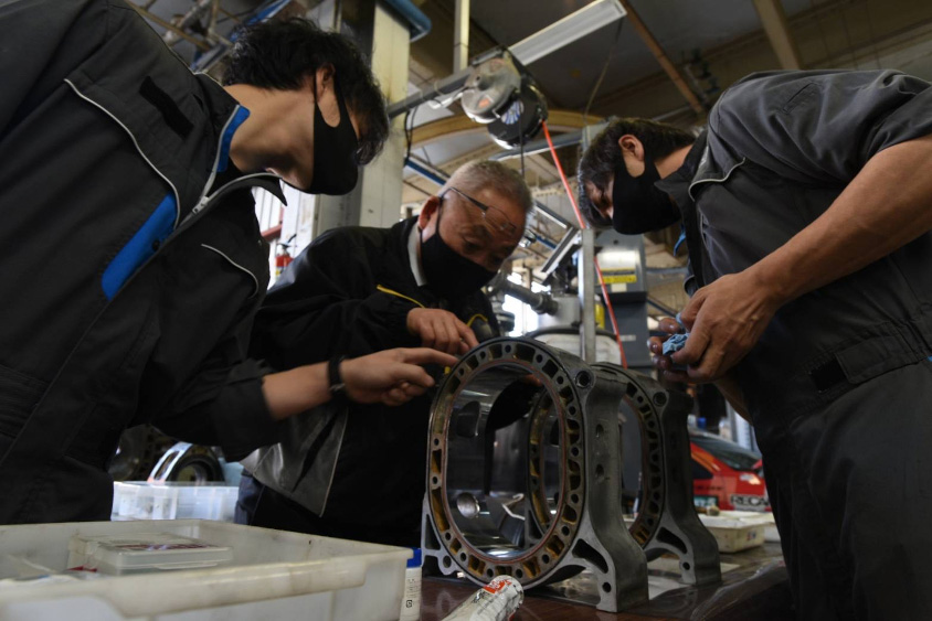 若手エンジニアにエンジン構造を教える河尻さん