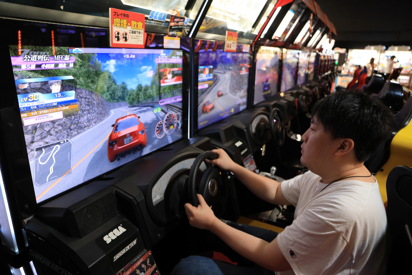 アーケードゲームをするトヨタ・86オーナーの上津さん